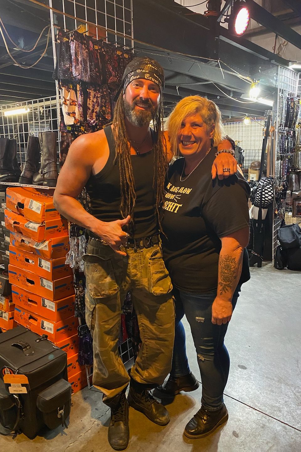 Attendee posing with a performer inside a vendor area featuring merchandise displays and event vendors.