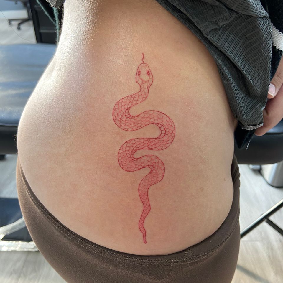 Image of a red crawling snake on a womans right side