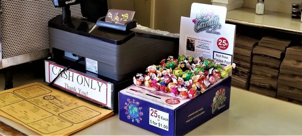 Honor box shown on counter top near cash register