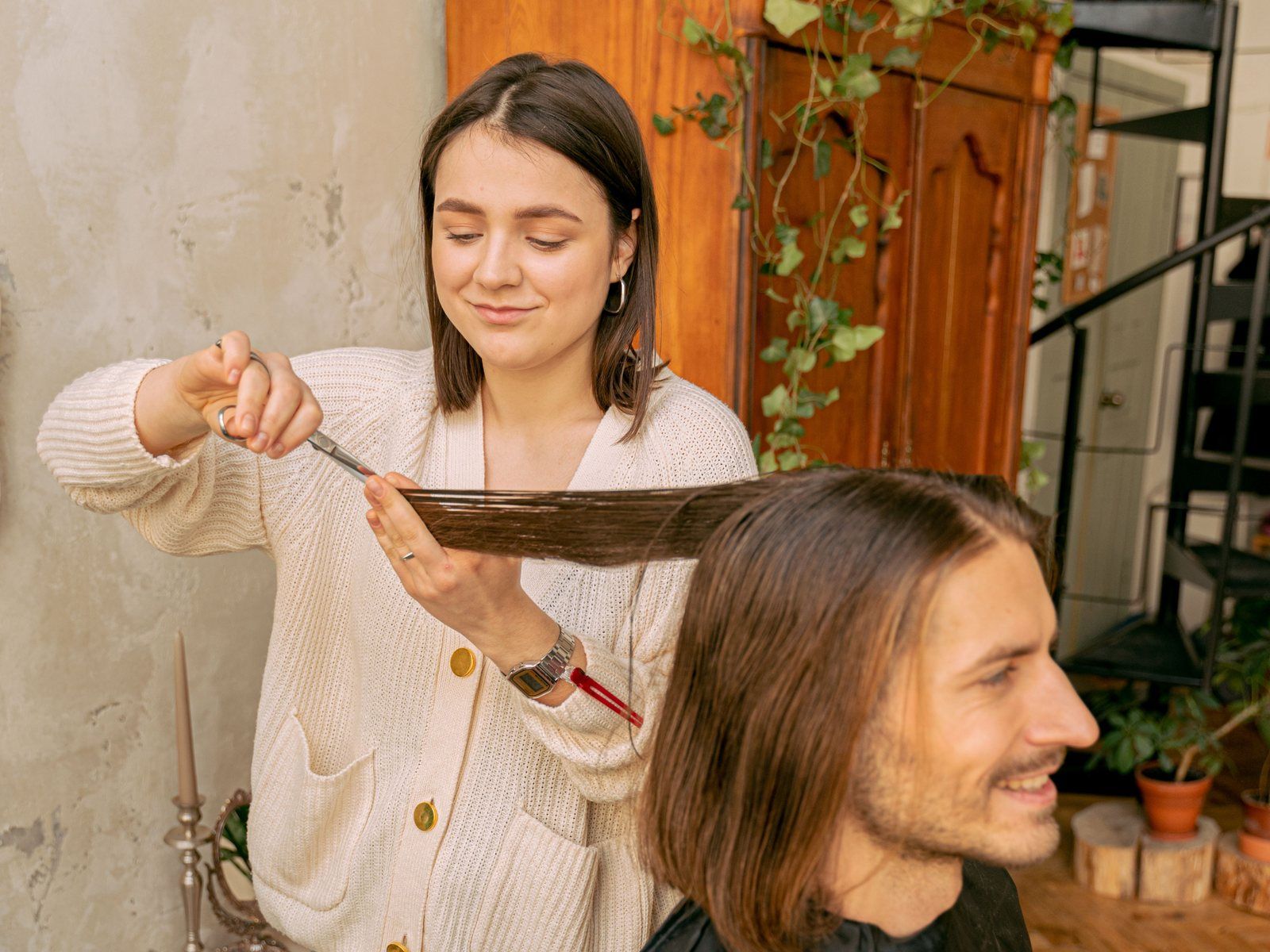 Hair stylist trimming a client’s hair in a local salon