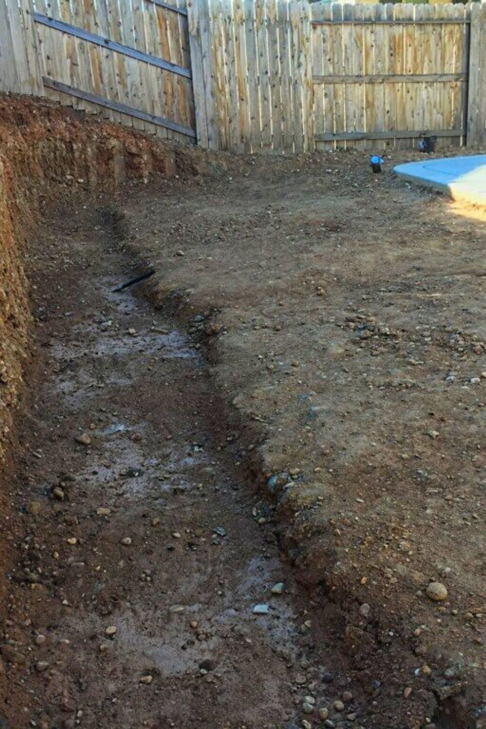 Backyard excavation and trenching by Alta Vista Landscaping & Tree Service, showing site preparation and soil grading before the installation of a concrete foundation and retaining wall in El Dorado County