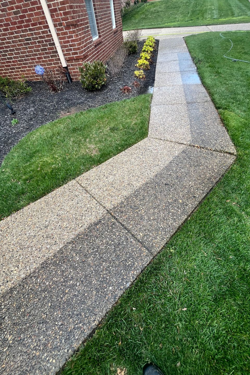Before and after concrete driveway pressure washing showcasing dramatic grime removal.