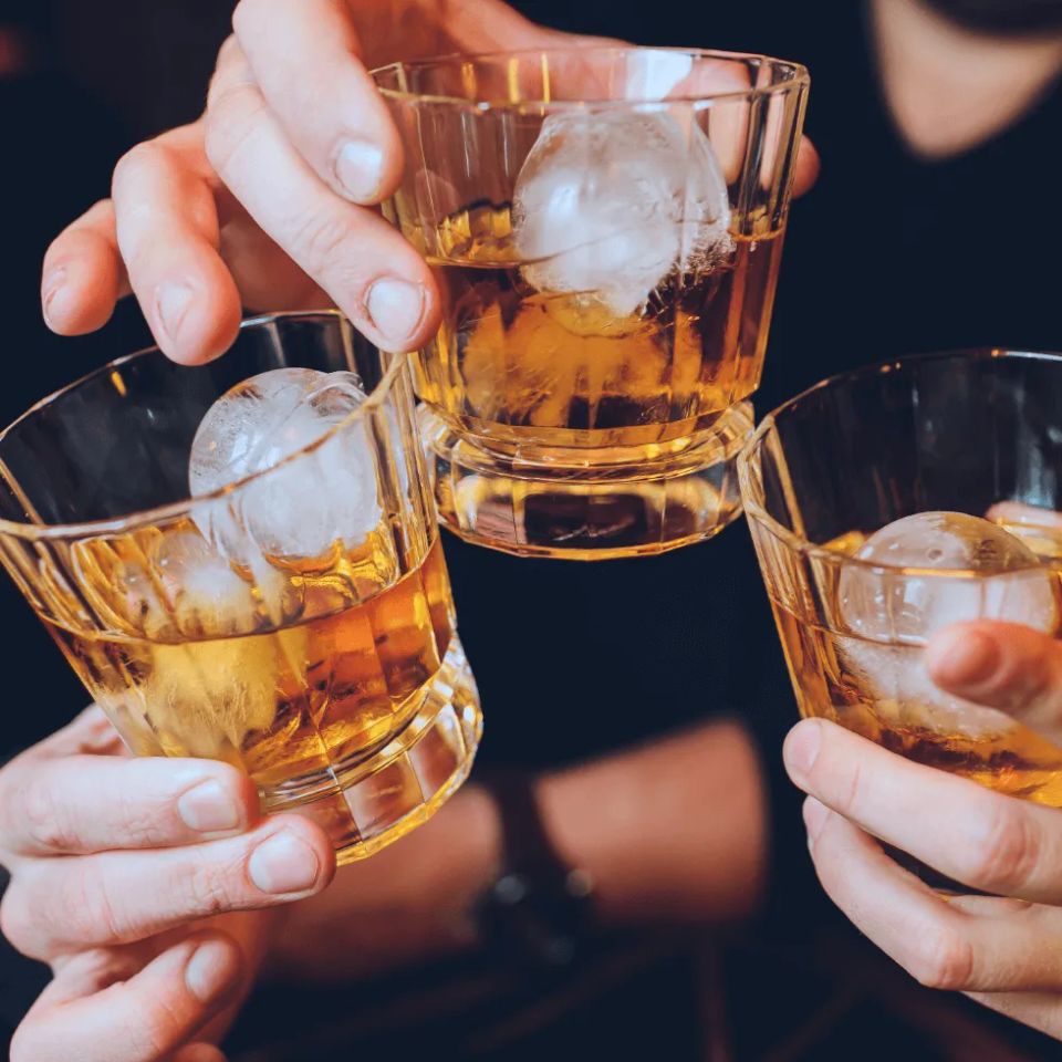 People clinking drink glasses together cheers