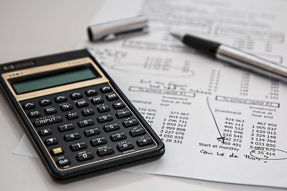 calculator with a pen and some marked up documents