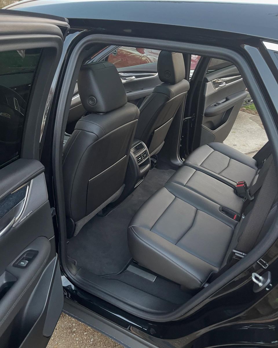 Spotless black leather rear seats and carpets after a full interior cleaning on a Cadillac in Wilmington Delaware