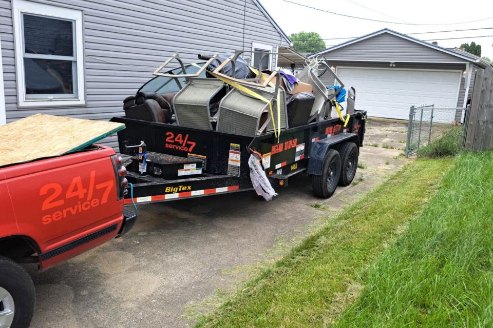 Rent-A-Man Dumpster Rentals trailer filled with furniture and household debris.