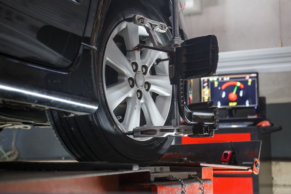 Car on stand with sensors on wheels for wheels alignment camber check in workshop of service station