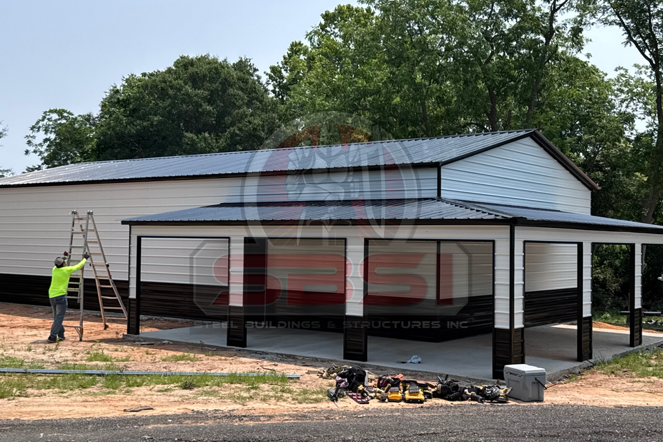 White and black steel garage with roll up doors and covered porch bays with SBSI watermark representing steel garages in Alabama