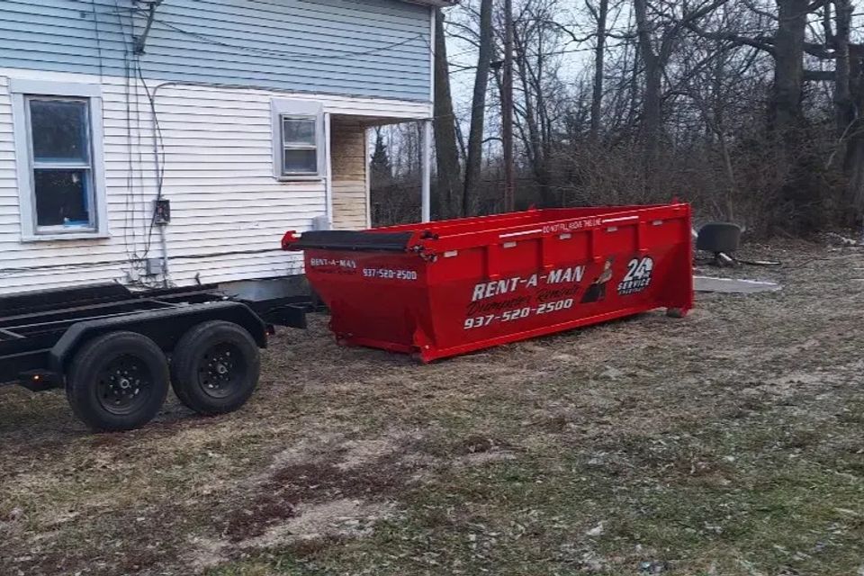 Rent-A-Man Dumpster Rentals dumpster placed next to a residential property.