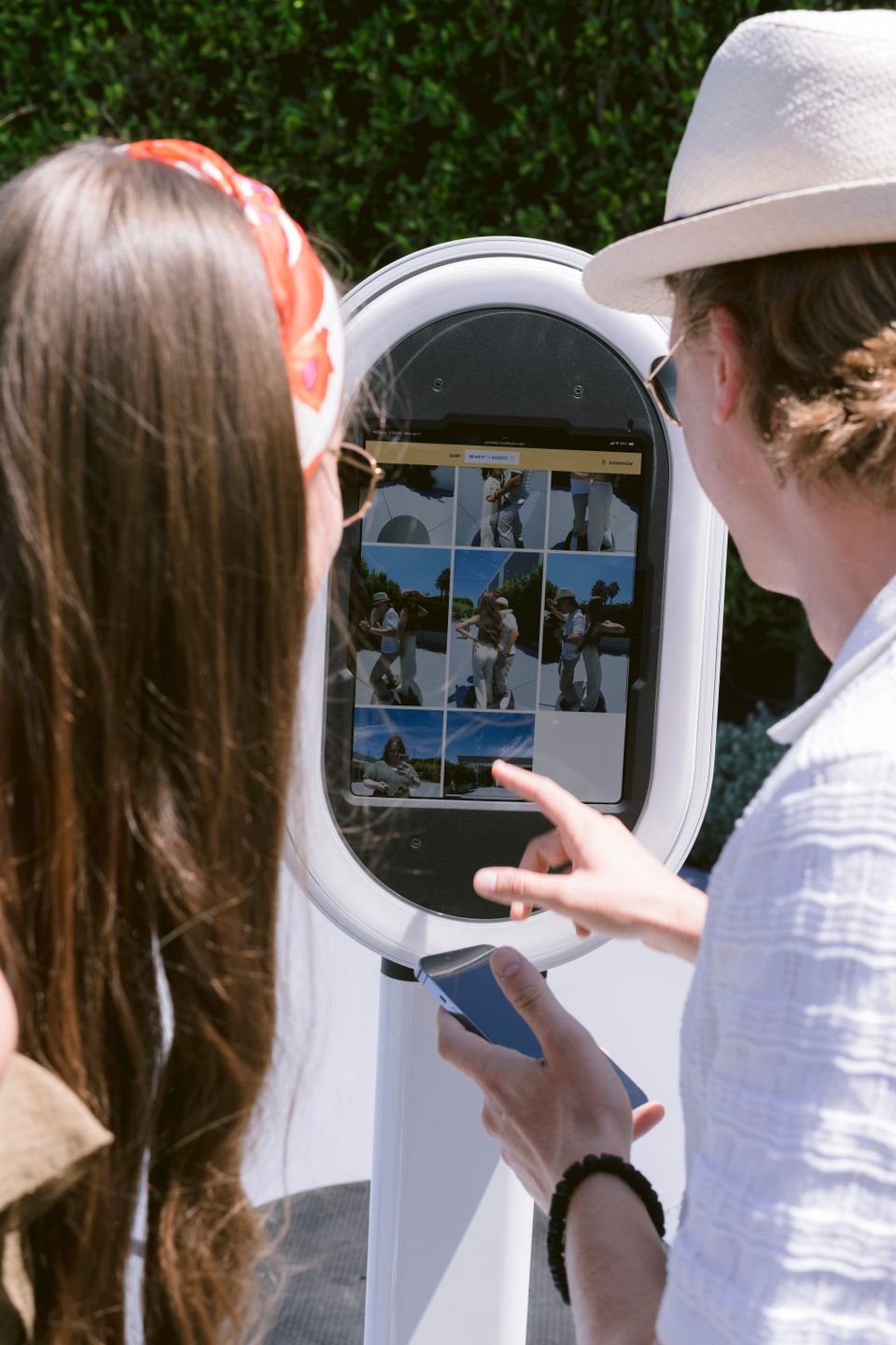 Couple browsing photo gallery on an outdoor photo booth.