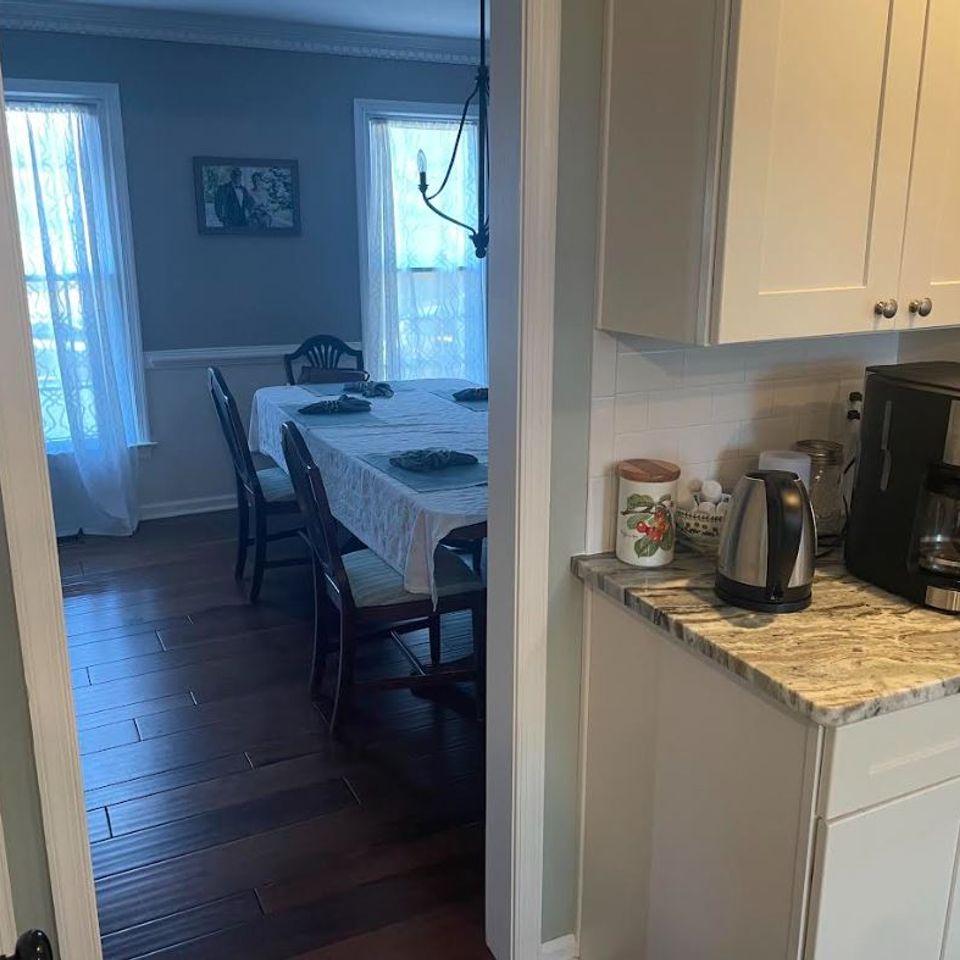 Tidy dining area and kitchen counter with neatly arranged appliances after a house cleaning service in Virginia Beach VA
