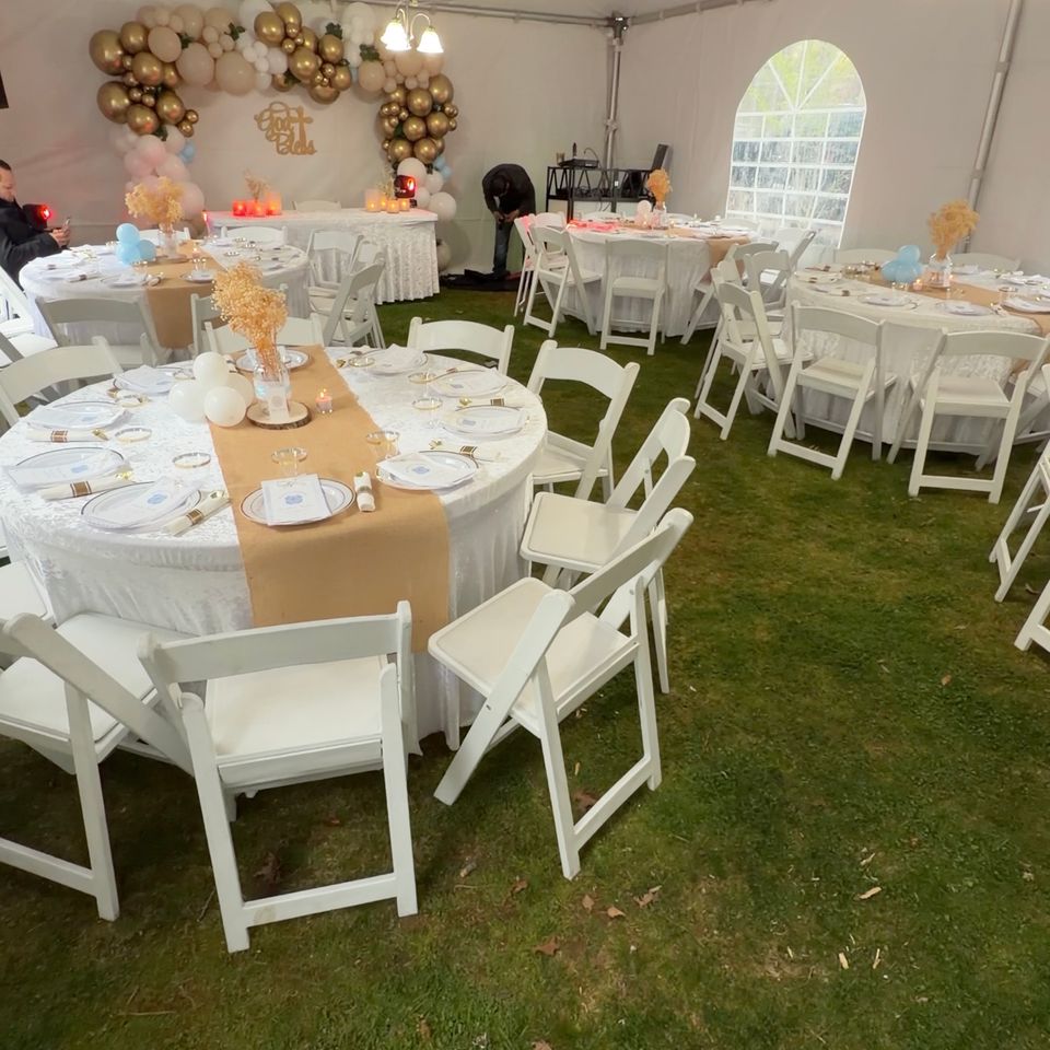 Full event setup with burlap-and-lace round tables and gold balloon backdrop under a tent in the Hamptons