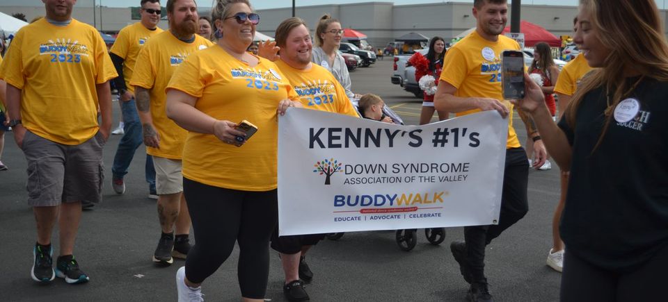 Buddy Walk participants carrying a team banner while walking together during the DSAV event.
