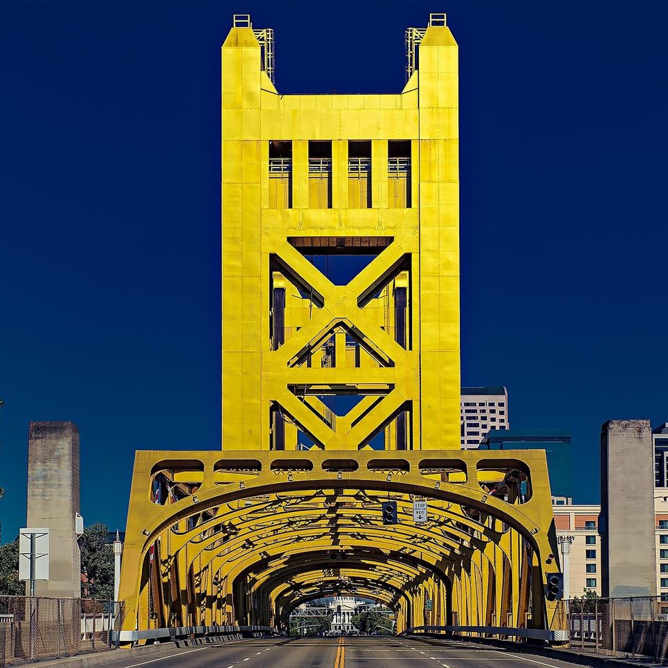 The iconic golden Tower Bridge in Sacramento against a clear blue sky—Artisan stone and tile services for the Greater Sacramento and West Sacramento areas.