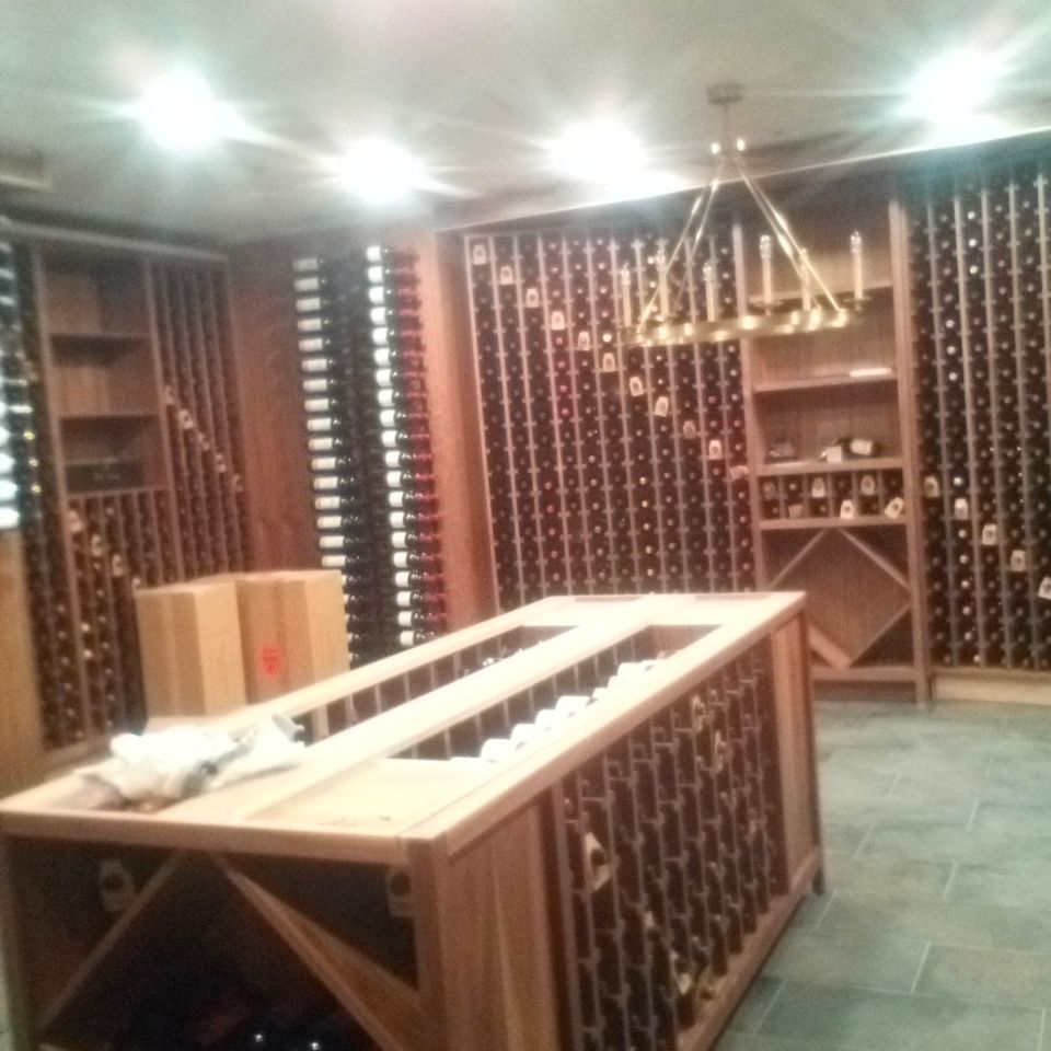 Custom wood wine cellar racking and tasting island cabinetry built for a Chagrin Falls home