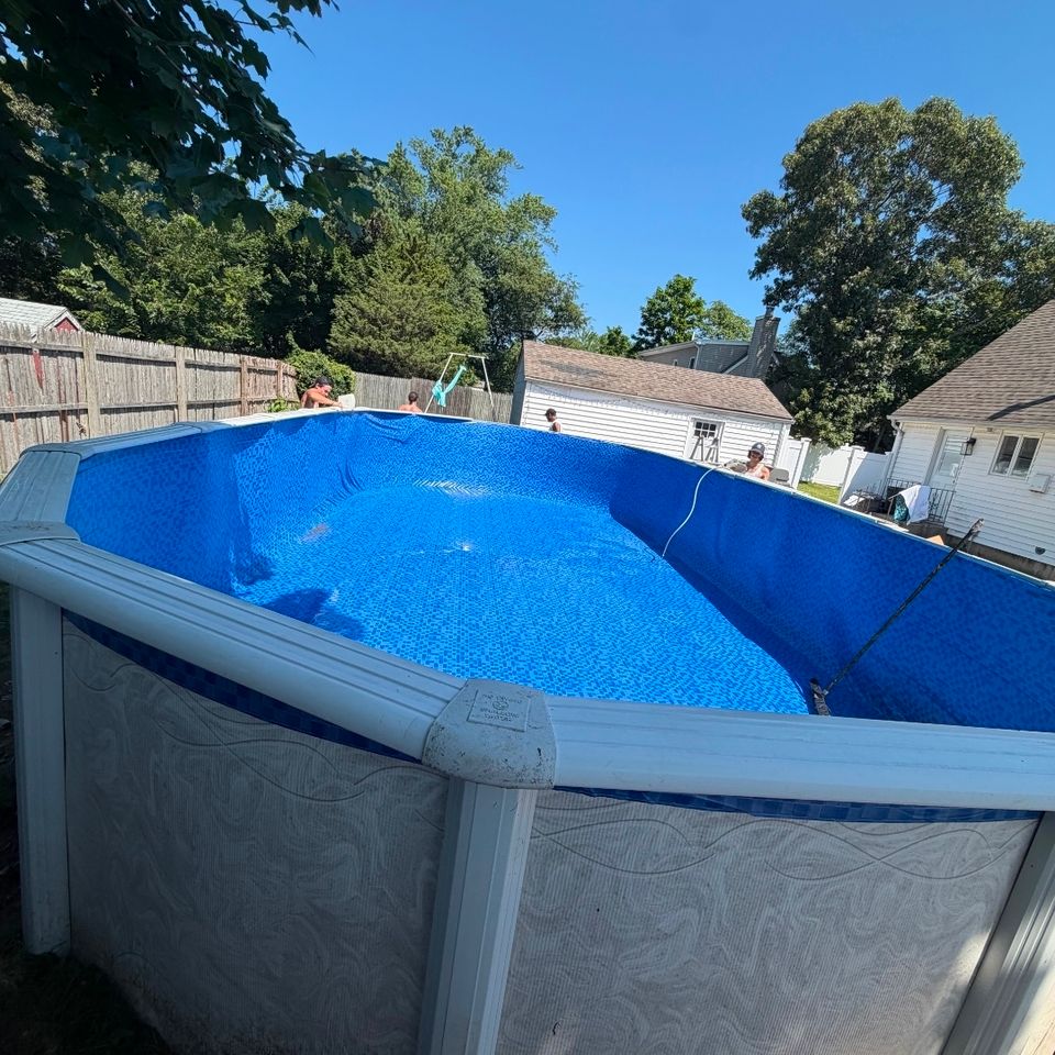 Oval above ground pool with a new mosaic pattern liner installed in a backyard
