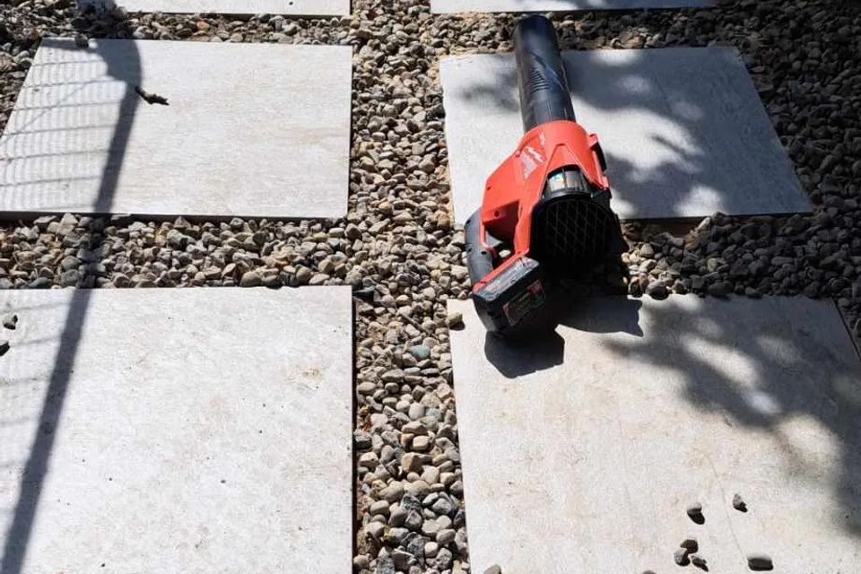 Square pavers set in a gravel pathway for easy backyard access.