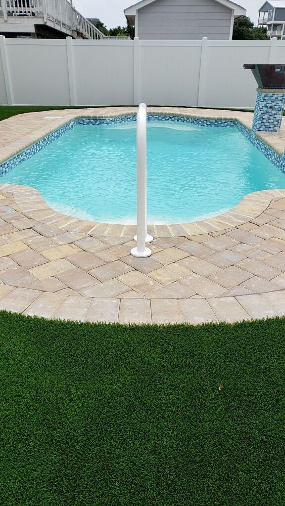 Pavers beautifully designed and installed around an inground pool.