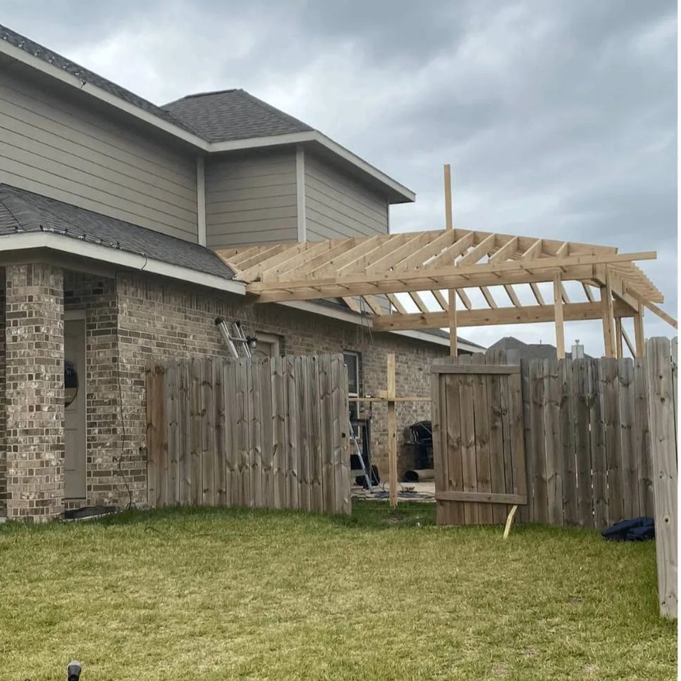 Backyard covered patio framing under construction behind a home in Spring TX
