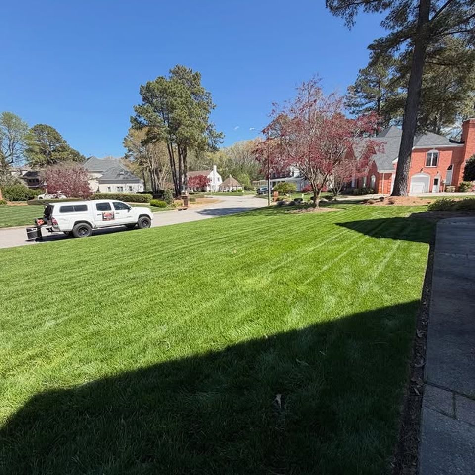 Far shot of cut grass for a client with the sun, done by Get A Mow On Lawn Care LLC of Chesapeake VA