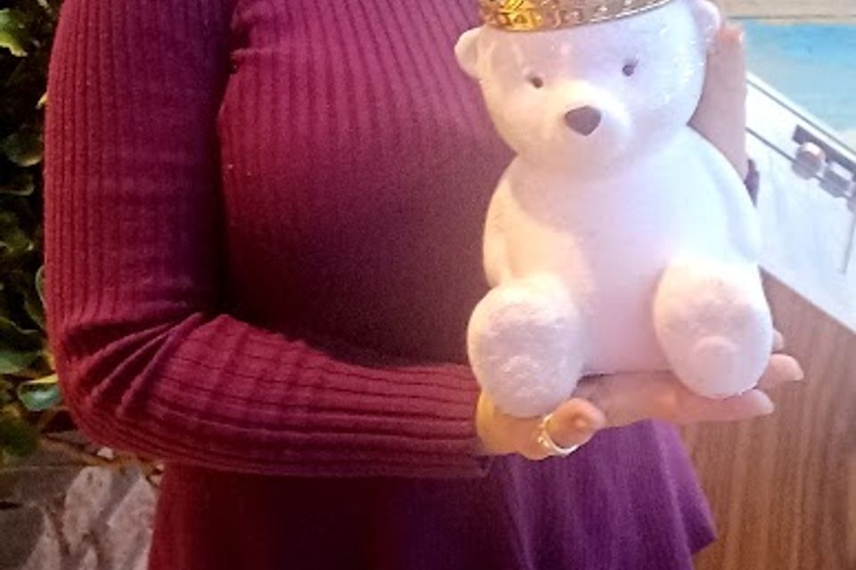 Girl holding white bear with crown