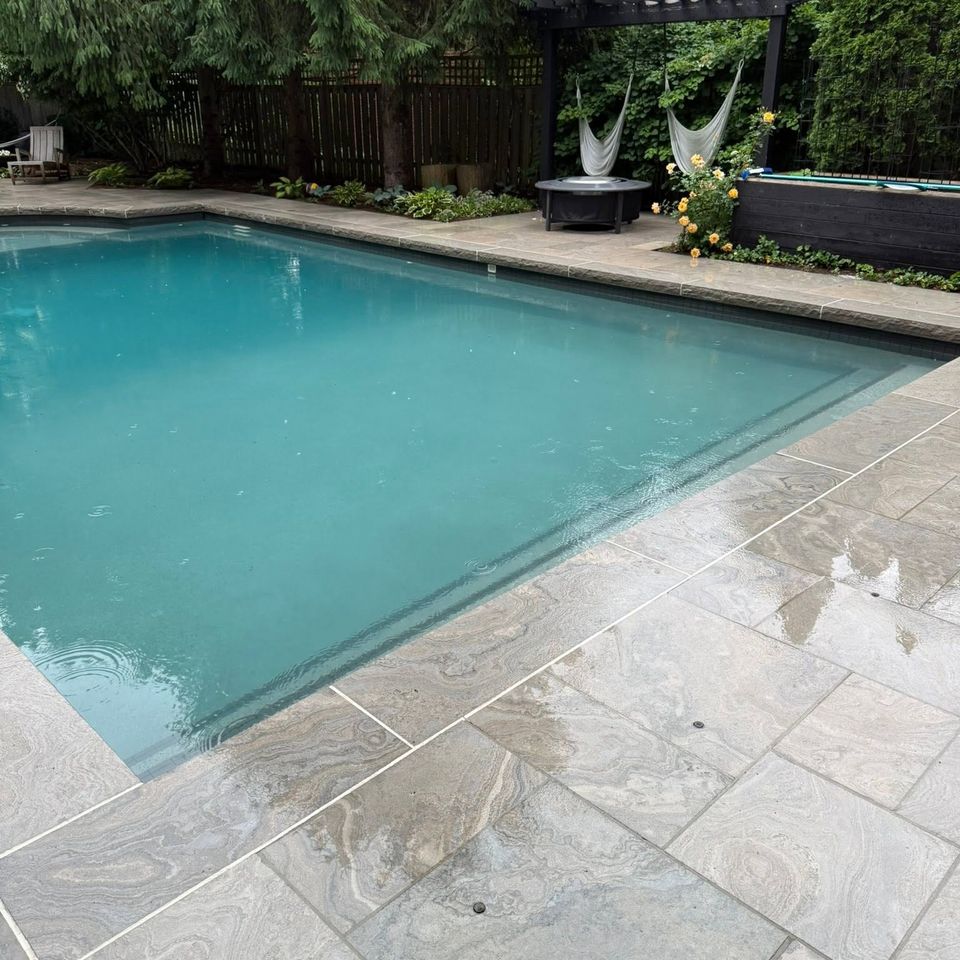 Freshly cleaned stone pool deck surrounding a backyard pool in Tillsonburg Ontario