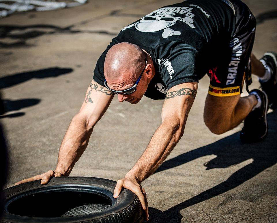 Exercising Picture of an athlete pushing a tire across the parking lot for leg, arm and core strength