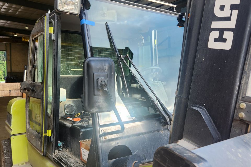 Forklift with a newly installed windshield in an industrial equipment glass repair facility.
