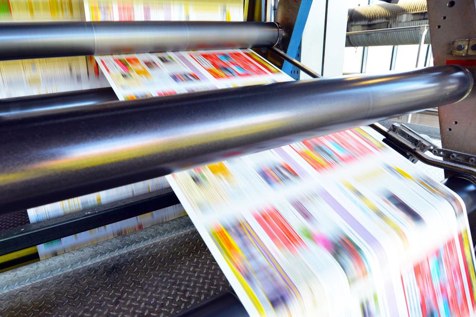 Commercial printing press producing colorful Every Door Direct Mail advertising pieces