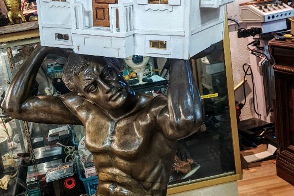 House held by man statue