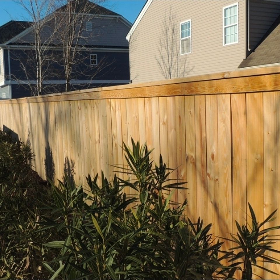 Wood privacy fence with cap rail installed along residential property line in Virginia Beach VA