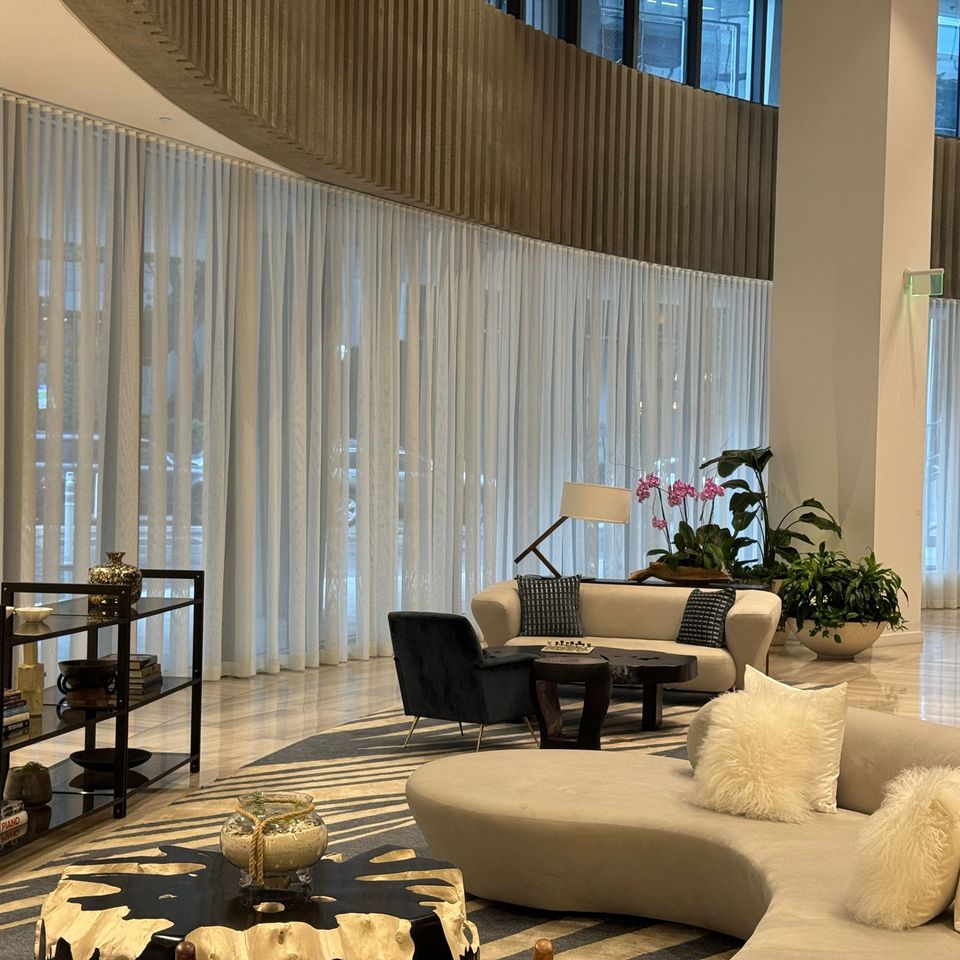 Floor-to-ceiling sheer curtains surrounding a luxury modern lounge area