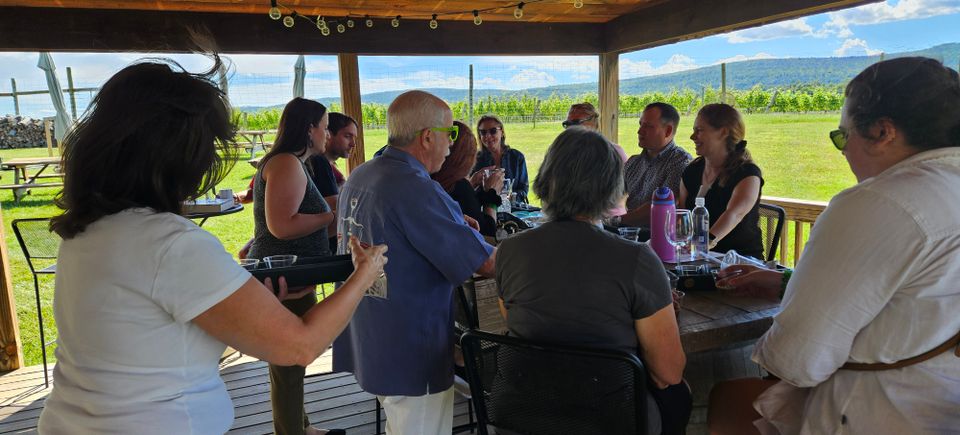 Group of friends enjoying their wines in front of a virginia vineyard