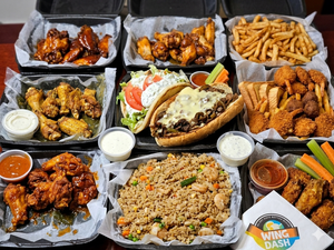 Assorted Wing Dash menu items including fried chicken, fried rice, seafood, fries, and wraps displayed in takeout containers from Wing Dash in Lewisville, Texas.