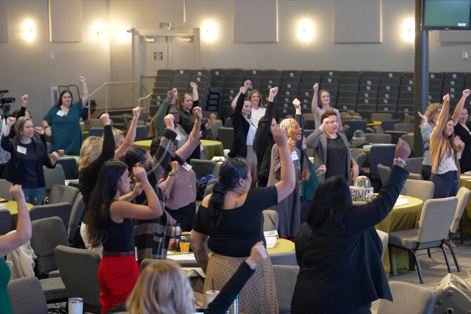 Group of people standing with raised arms
