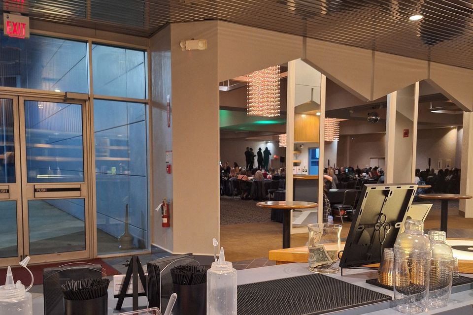 Long bar counter stocked with bottles, mixers, and service tools