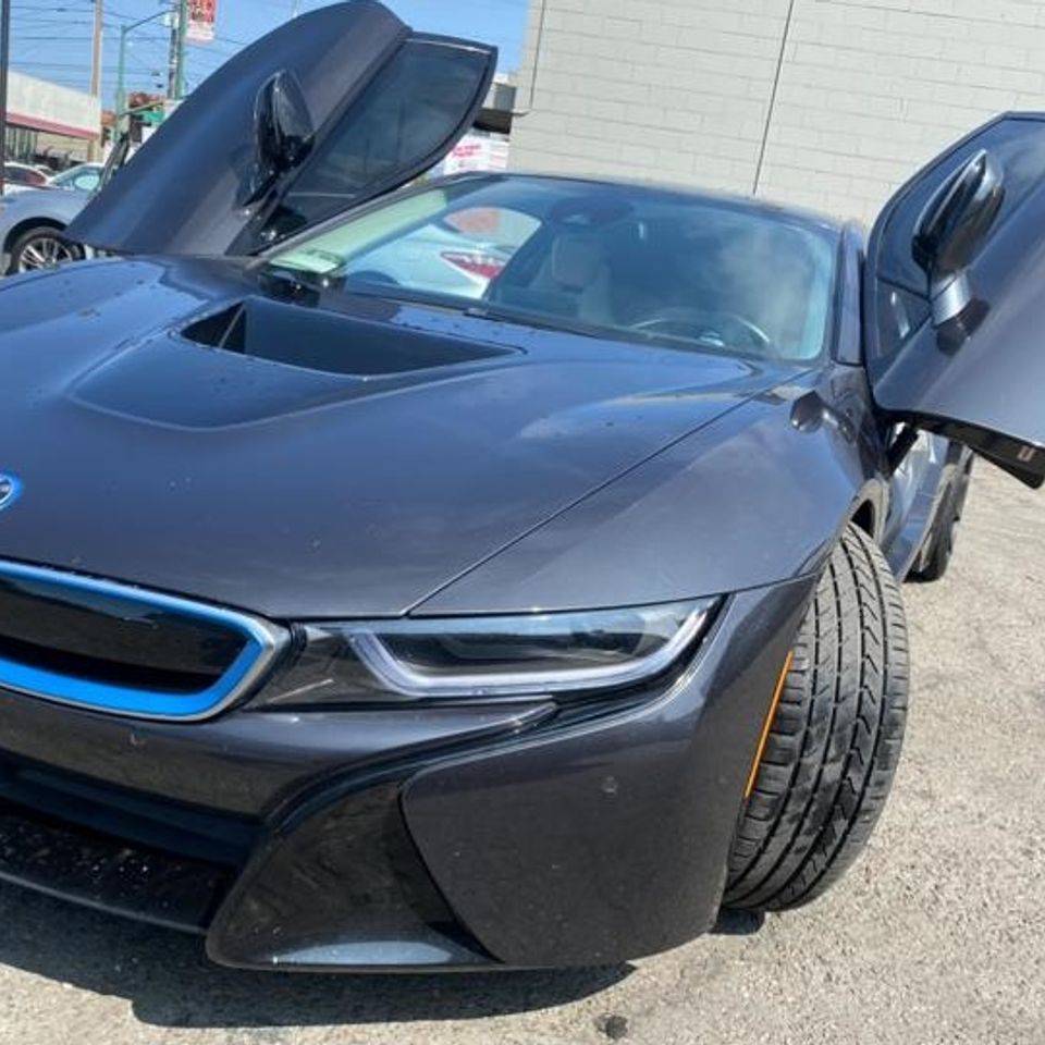 Black luxury BMW with upward-flipped doors in a photo