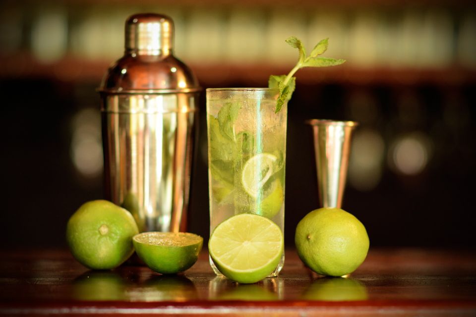 Lime mocktail served with fresh mint, lime slices, and bar tools arranged on a countertop.