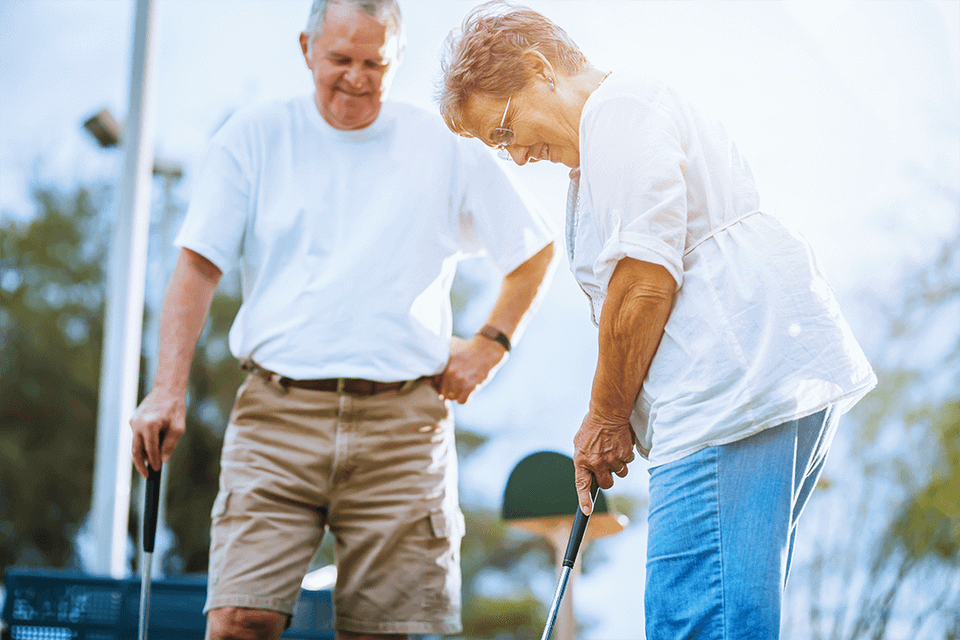 Old couple playing golf