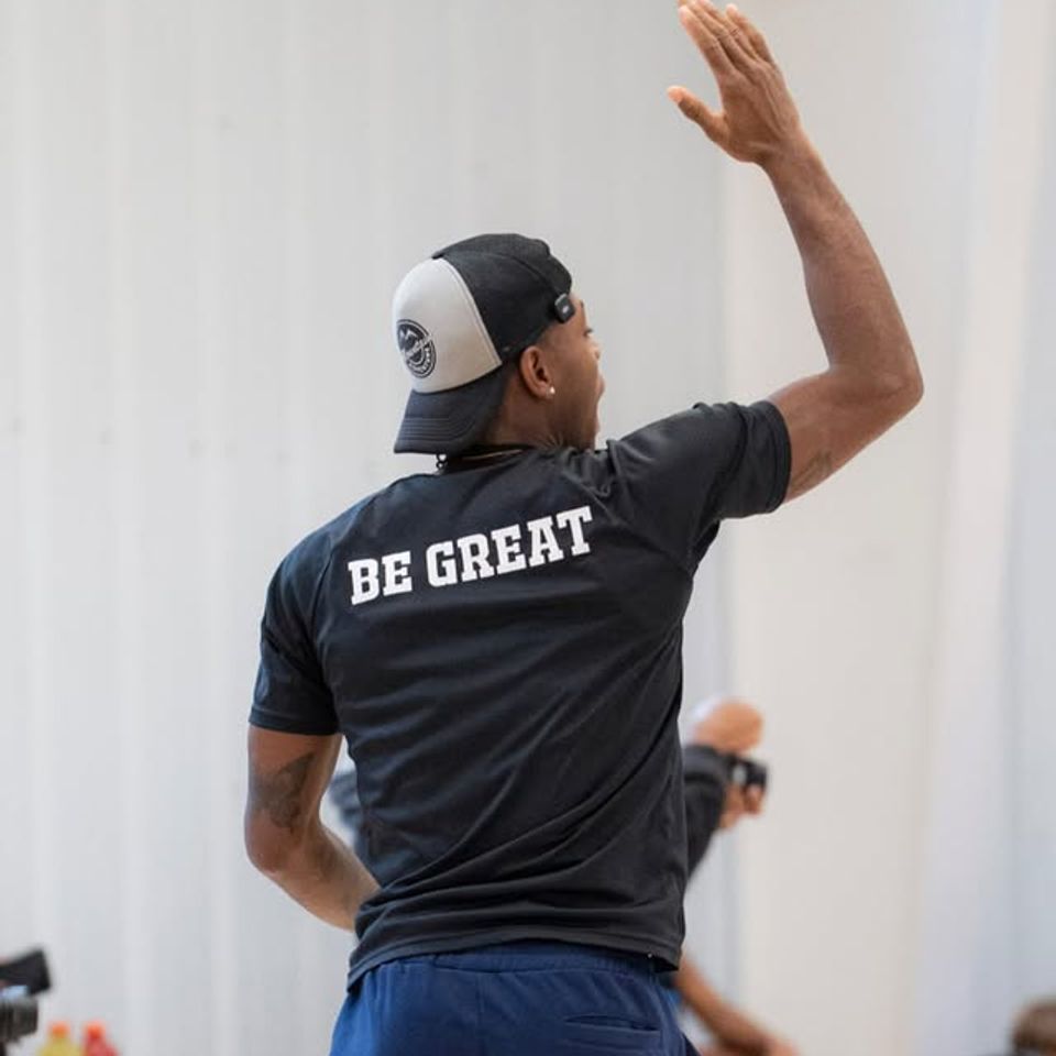 Xavier Allen wearing a shirt that says "be great" on the back