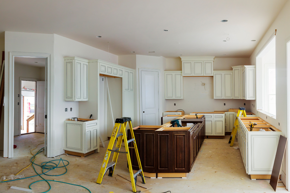 Kitchen undergoing a home remodeling project with new custom cabinets, a center island, and ongoing construction work.