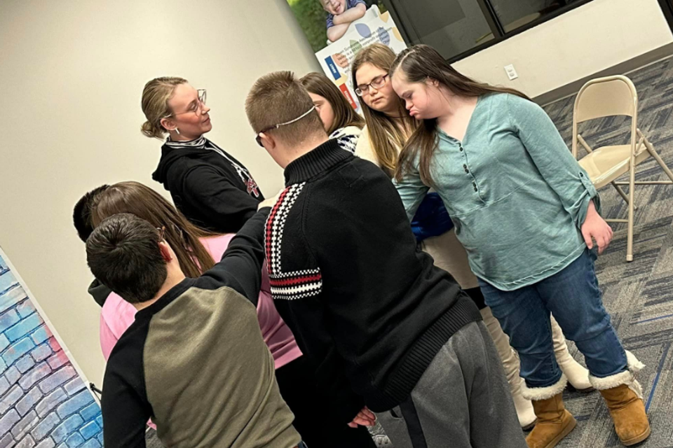Participants with Down syndrome taking part in a group improvisation activity with guidance from an instructor.