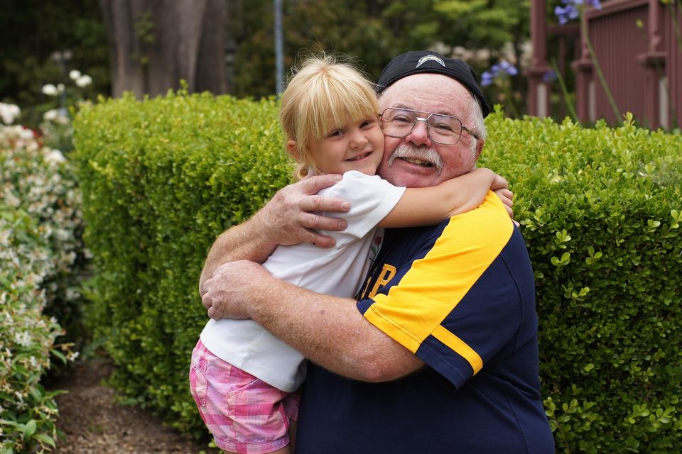 Grandfather and granddaughter happy and hugging at home