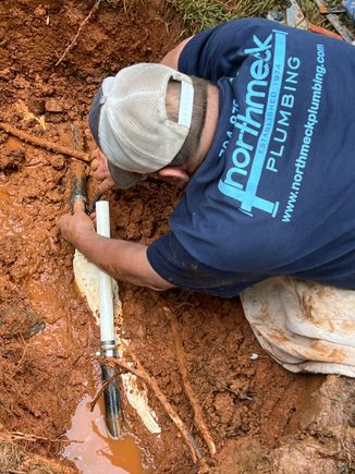 Kenny working on broken pipe in the ground plumber