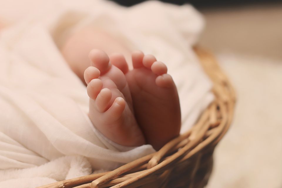 Baby s feet on brown wicker basket 161534