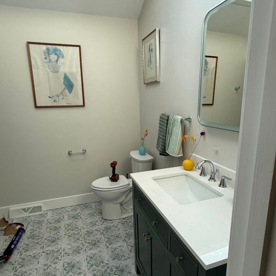 Powder room remodel with dark green vanity, quartz top, and patterned tile floor in Cleveland Heights