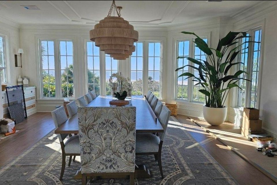 Bright dining room with long table and custom white trim installation around the windows