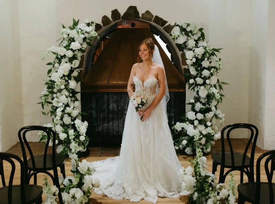 Bride standing with white and green floral arches available for rent in Denver, Colorado 