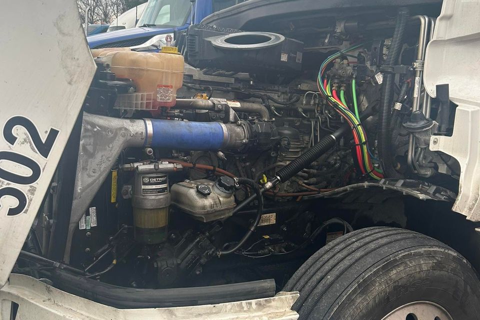 Detroit diesel engine bay exposed under raised hood during semi-truck repair in Arab Alabama