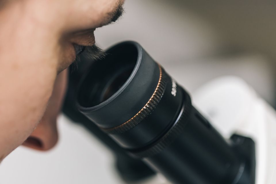 Scientist looking through microscope